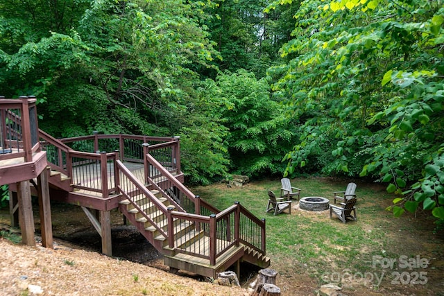 view of yard featuring a fire pit, stairway, and a wooden deck