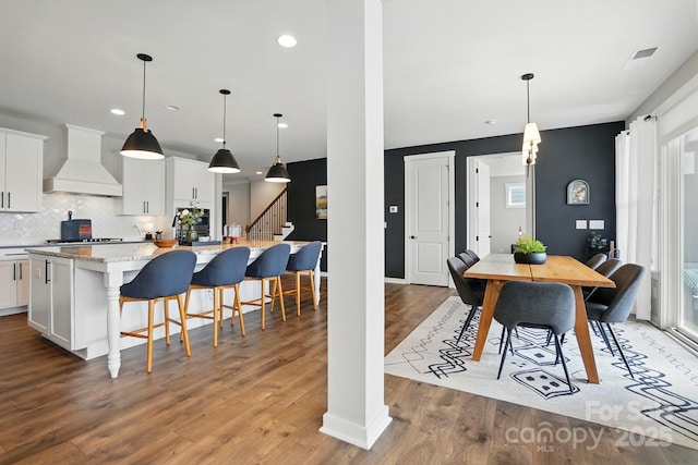 2062 Nellies Way, Fort Mill, SC 29715 - kitchen with premium range hood, a large island with sink, light wood-type flooring, white cabinets, and decorative backsplash