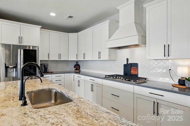 2062 Nellies Way, Fort Mill, SC 29715 - kitchen with appliances with stainless steel finishes, custom exhaust hood, a sink, white cabinetry, and backsplash