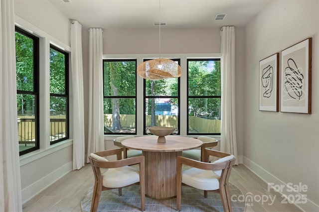 dining area featuring light wood finished floors and baseboards