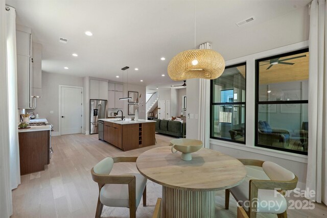 dining space featuring recessed lighting, light wood-style flooring, stairs, ceiling fan, and baseboards