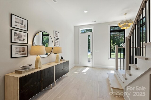 entryway featuring wood finished floors, stairway, a chandelier, baseboards, and recessed lighting