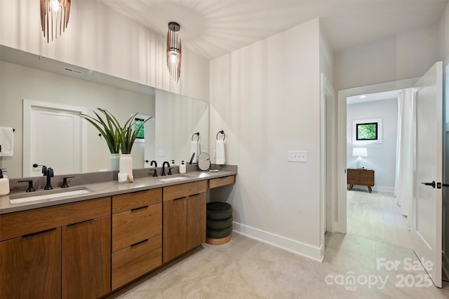 full bathroom with double vanity, baseboards, and tile patterned flooring