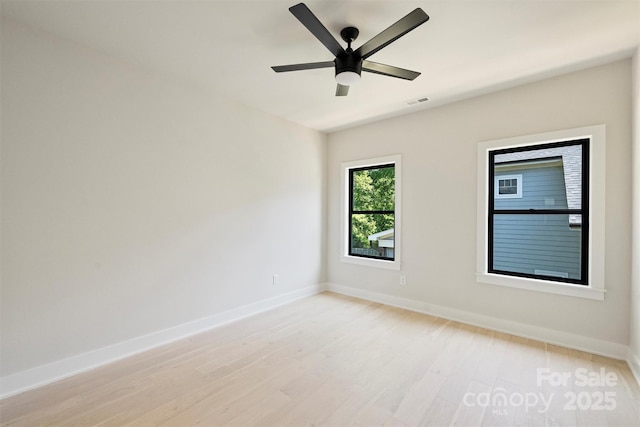 unfurnished room with baseboards, light wood-type flooring, and a ceiling fan