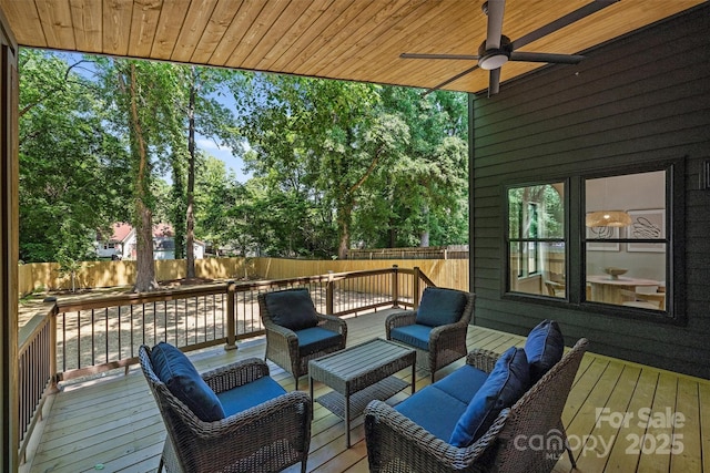 wooden terrace featuring an outdoor hangout area, a fenced backyard, and a ceiling fan