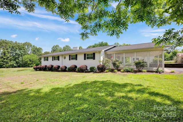 ranch-style house with a chimney, a front lawn, and brick siding