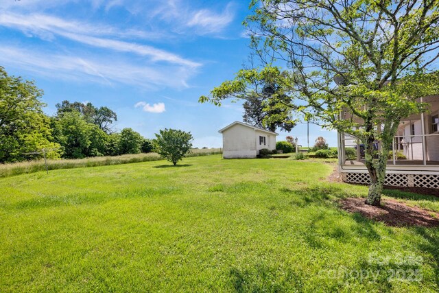 view of green lawn with a wooden deck