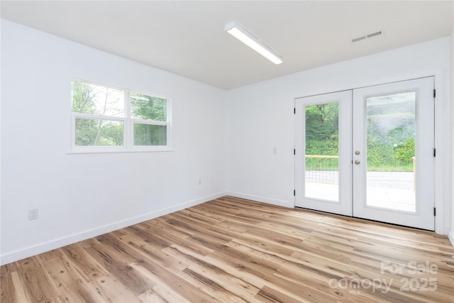 1318 Crawford Rd, Waynesville, NC 28785 - empty room with french doors, plenty of natural light, and light wood-style floors