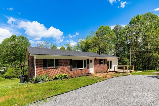 1318 Crawford Rd, Waynesville, NC 28785 - ranch-style house with brick siding, central AC unit, a wooden deck, and a front yard