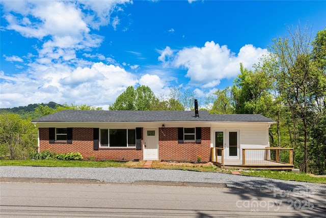 1318 Crawford Rd, Waynesville, NC 28785 - single story home featuring french doors, brick siding, and a wooden deck