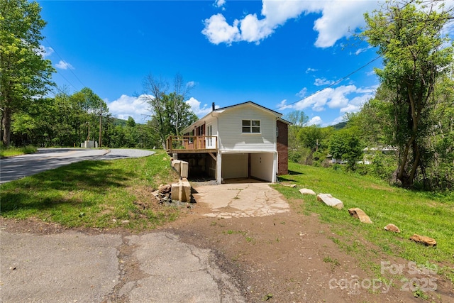 1318 Crawford Rd, Waynesville, NC 28785 - view of home's exterior with asphalt driveway, a lawn, and a wooden deck