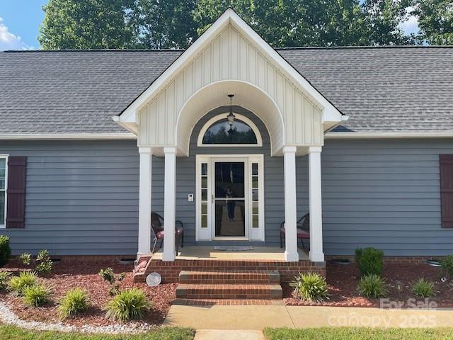 517 Grassy Creek Run, Chester, SC 29706 - doorway to property featuring covered porch, board and batten siding, and roof with shingles