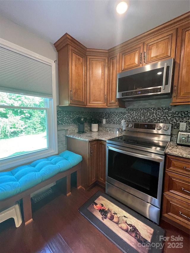 517 Grassy Creek Run, Chester, SC 29706 - kitchen with stainless steel appliances, brown cabinets, decorative backsplash, dark wood-type flooring, and light stone countertops