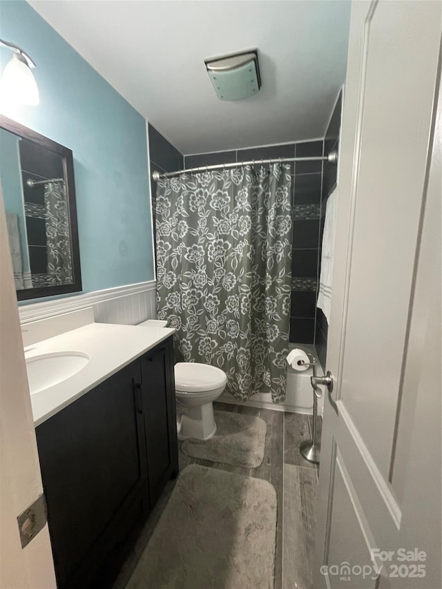 517 Grassy Creek Run, Chester, SC 29706 - full bath with vanity, toilet, a wainscoted wall, wood finished floors, and curtained shower