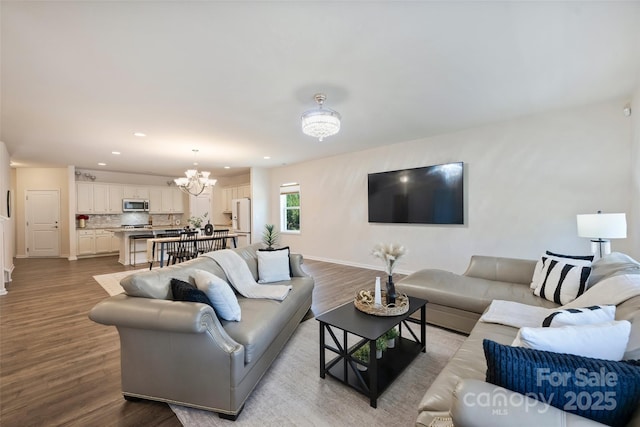 living room featuring wood finished floors, recessed lighting, a chandelier, and baseboards
