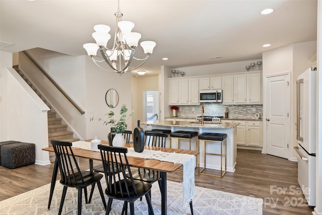 dining area with dark wood-style floors, stairway, a chandelier, recessed lighting, and baseboards