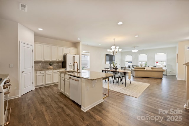 kitchen featuring white appliances, a sink, white cabinetry, dark wood-style flooring, and recessed lighting