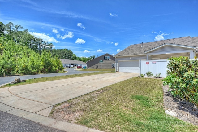 view of side of home with driveway, a garage, and a lawn