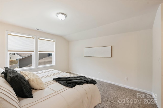 carpeted bedroom featuring vaulted ceiling and baseboards
