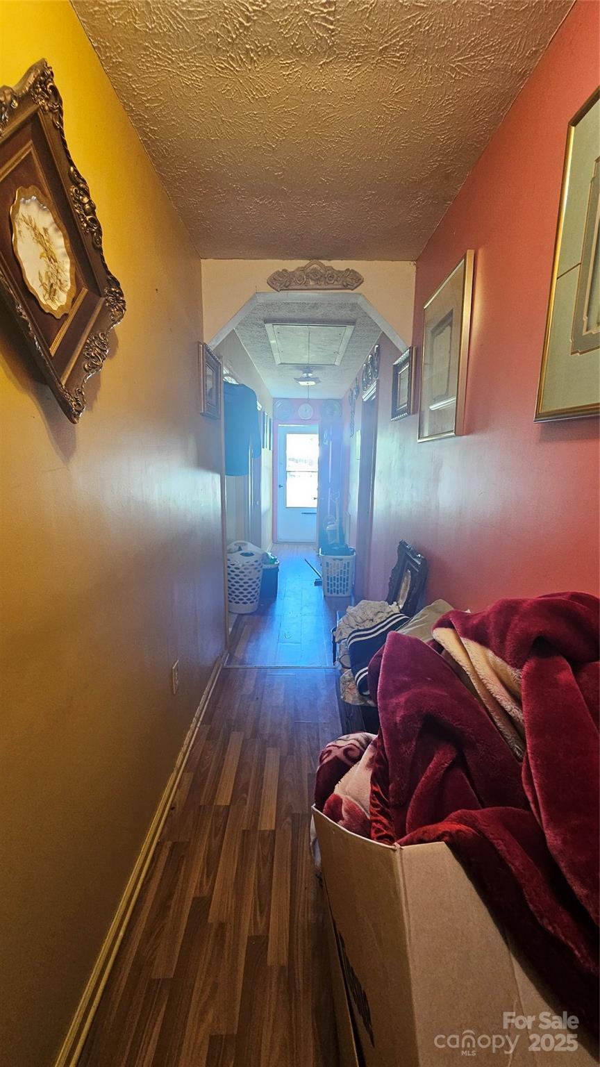 2704 Chambers St, Lumberton, NC 28358 - corridor with wood finished floors, arched walkways, and a textured ceiling