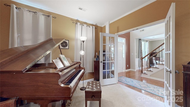 living area featuring crown molding, baseboards, stairs, french doors, and wood finished floors