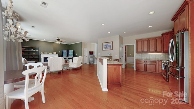 kitchen featuring stainless steel appliances, open floor plan, ceiling fan, light wood-type flooring, and light stone counters