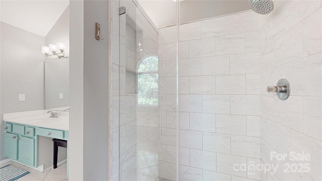 full bathroom featuring tiled shower and vanity
