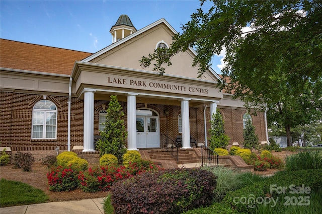view of exterior entry featuring brick siding