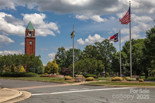 view of asphalt street with curbs, view of scattered trees, and sidewalks