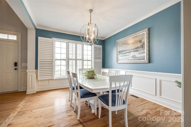 208 Mcduffie Ln, Fort Mill, SC 29715 - dining space featuring a chandelier, a decorative wall, light wood-style floors, ornamental molding, and wainscoting