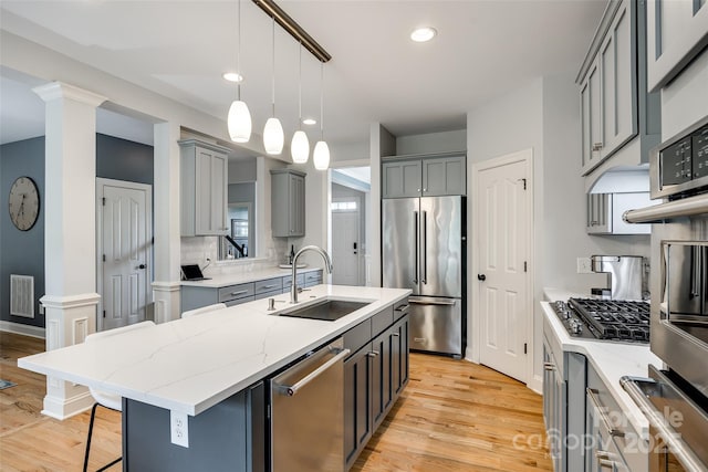 208 Mcduffie Ln, Fort Mill, SC 29715 - kitchen featuring a sink, appliances with stainless steel finishes, gray cabinetry, light wood-style floors, and light stone countertops