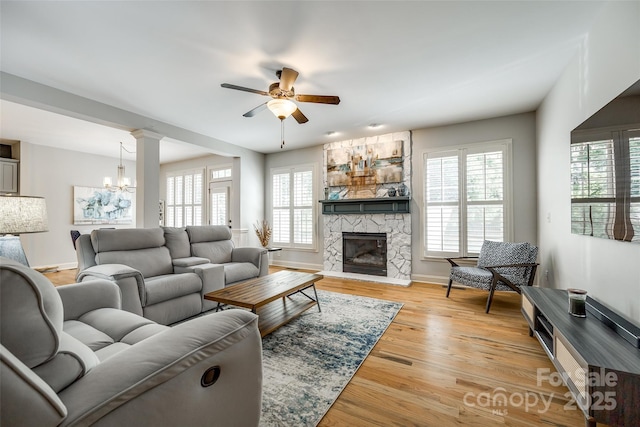 208 Mcduffie Ln, Fort Mill, SC 29715 - living room featuring a ceiling fan, a stone fireplace, healthy amount of natural light, and light wood-style flooring