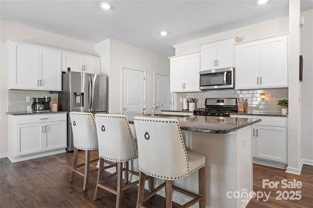 446 Misty Law Ln, Clover, SC 29710 - kitchen with stainless steel appliances, tasteful backsplash, dark wood finished floors, white cabinets, and recessed lighting