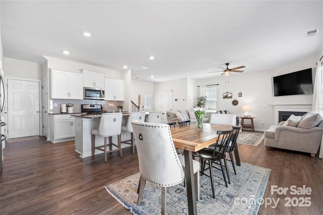 446 Misty Law Ln, Clover, SC 29710 - dining space featuring a ceiling fan, dark wood-style flooring, recessed lighting, stairs, and a fireplace