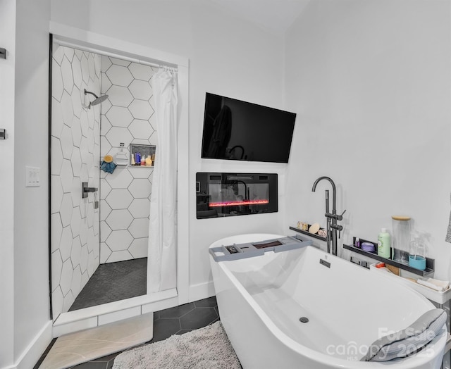 5262 Mckenzie Trl, Conover, NC 28613 - bathroom featuring tiled shower, tile patterned floors, a freestanding tub, a glass covered fireplace, and baseboards