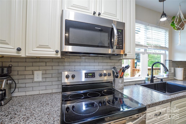 8024 Eagle St, Mount Pleasant, NC 28124 - kitchen with appliances with stainless steel finishes, a sink, tasteful backsplash, white cabinetry, and light stone countertops