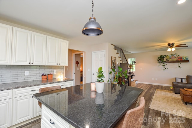 8024 Eagle St, Mount Pleasant, NC 28124 - kitchen with open floor plan, a ceiling fan, dark wood-type flooring, decorative backsplash, and white cabinetry