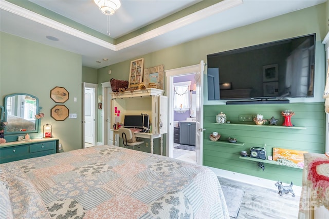 bedroom with ornamental molding, a raised ceiling, and ensuite bathroom