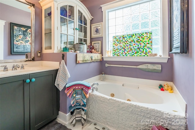 full bathroom featuring a tub with jets and vanity