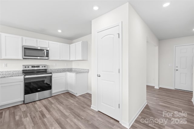 2322 Joes Lake Rd, Shelby, NC 28152 - kitchen with stainless steel appliances, light wood-type flooring, white cabinetry, recessed lighting, and baseboards