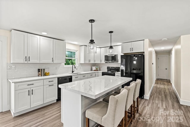 139 Elysian Dr, Mooresville, NC 28117 - kitchen featuring black appliances, a sink, light wood finished floors, backsplash, and white cabinetry