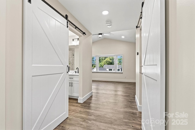 139 Elysian Dr, Mooresville, NC 28117 - hall with a barn door, lofted ceiling, wood finished floors, baseboards, and a sink