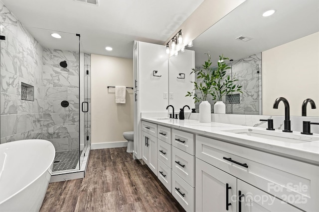 139 Elysian Dr, Mooresville, NC 28117 - full bathroom with recessed lighting, a shower stall, a freestanding tub, double vanity, and wood finished floors