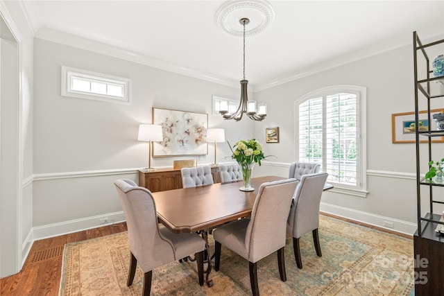 6831 Conservatory Ln, Charlotte, NC 28210 - dining space featuring a chandelier, wood finished floors, ornamental molding, healthy amount of natural light, and baseboards