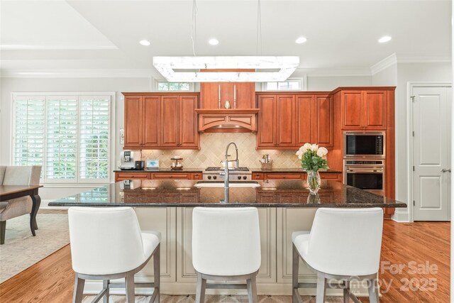 6831 Conservatory Ln, Charlotte, NC 28210 - kitchen with oven, crown molding, built in microwave, backsplash, and light wood-style floors