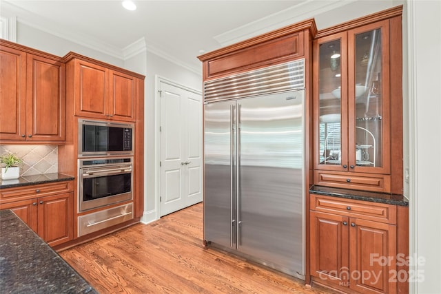 6831 Conservatory Ln, Charlotte, NC 28210 - kitchen featuring built in appliances, a warming drawer, light wood-style floors, brown cabinets, and crown molding