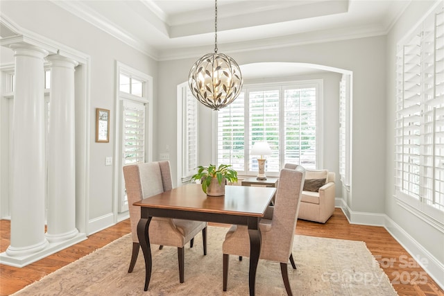 6831 Conservatory Ln, Charlotte, NC 28210 - dining room featuring a raised ceiling, a chandelier, light wood finished floors, ornamental molding, and baseboards