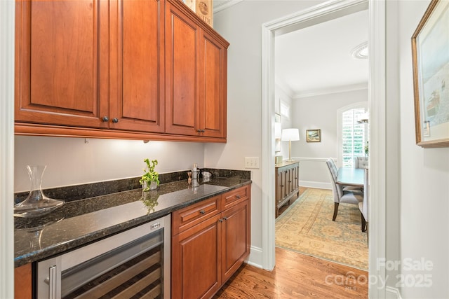 6831 Conservatory Ln, Charlotte, NC 28210 - bar area with wine cooler, ornamental molding, light wood-style flooring, and baseboards