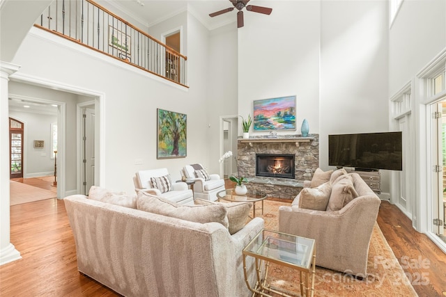6831 Conservatory Ln, Charlotte, NC 28210 - living room featuring crown molding, a stone fireplace, a high ceiling, wood finished floors, and ceiling fan