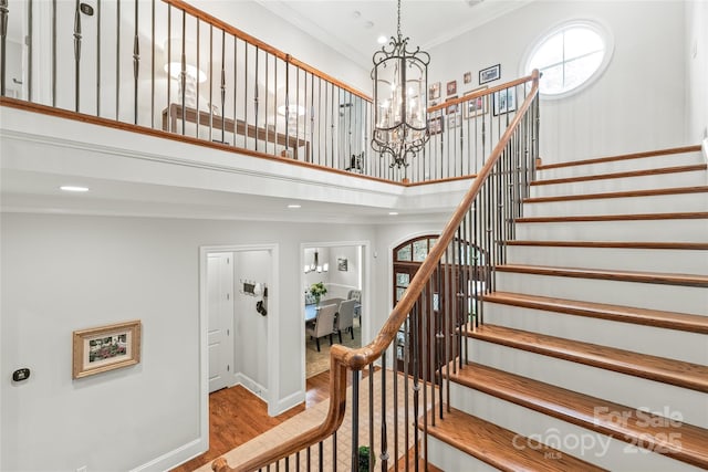 6831 Conservatory Ln, Charlotte, NC 28210 - staircase with wood finished floors, a towering ceiling, a chandelier, recessed lighting, and ornamental molding
